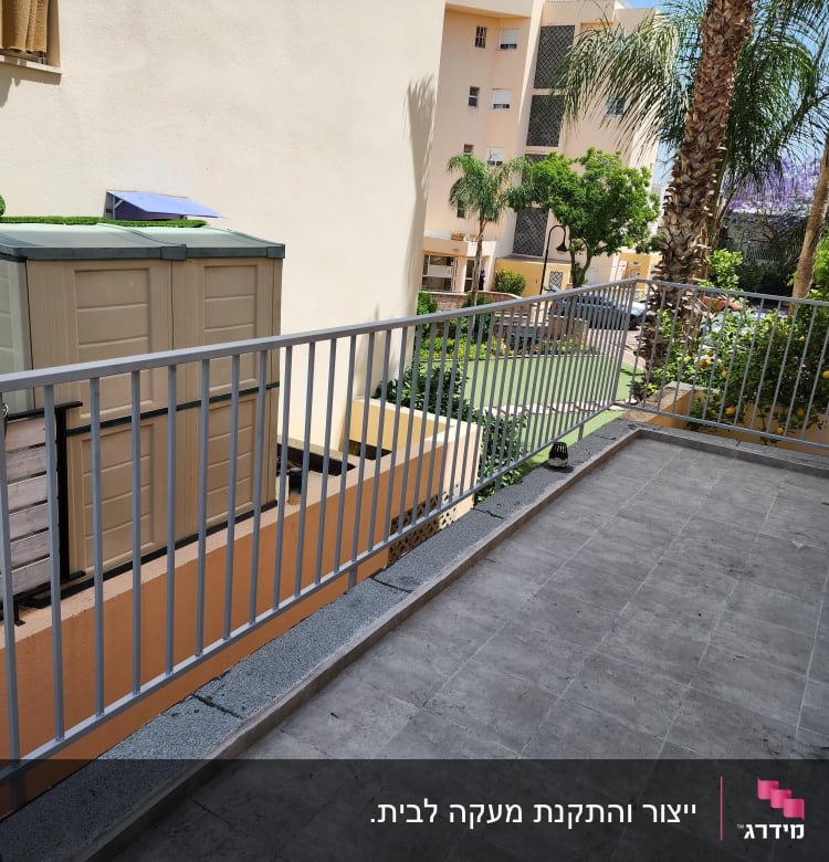 מעקה מתכת אפור במרפסת עם רצפת אריחים אפורה